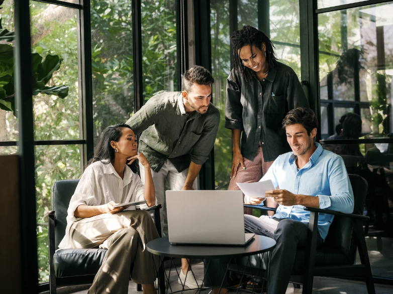 A team collaborating around a laptop in a modern office